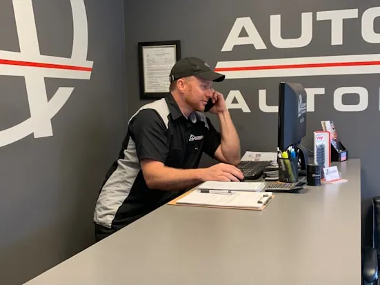 A salesperson on the phone at a dealership desk